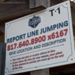 Sign stating to report line jumpers at Six Flags over Texas