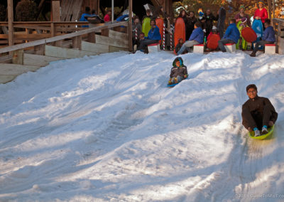 Guests sledding down snow hill