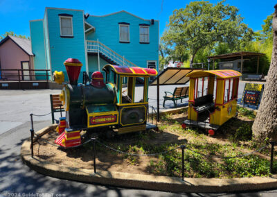 Old kiddie train pieces in a landscaping bed