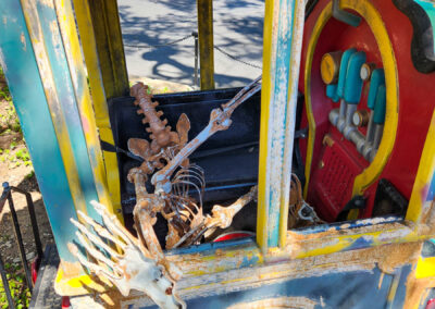 Skeleton lays in an old kiddie train engine