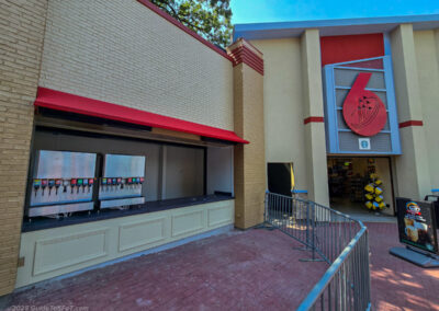 A drink refill station being installed between Six Flags Photos and the Six Flags Universe store