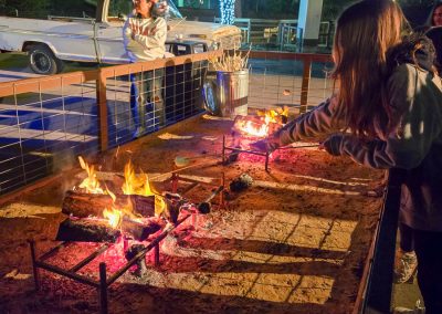 Guests roast s'mores over a campfire in the Texas section