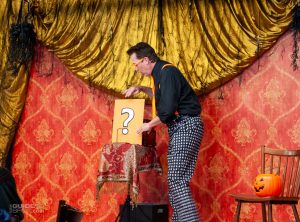 Magician Mike Williams holding an envelope with a giant question mark